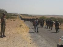 FSA fighters walking along a road towards Jerablus